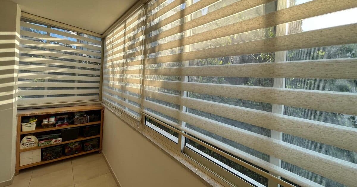 וילונות זברה בגוון בז׳ במרפסת סגורה